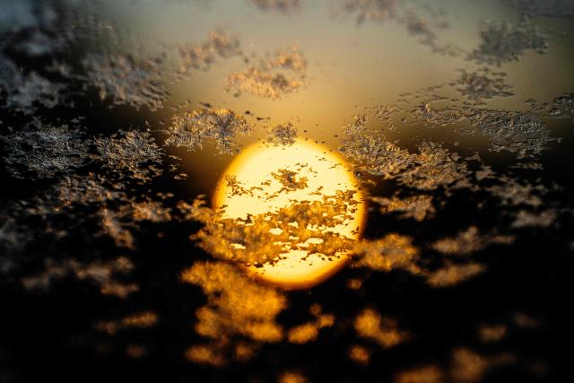 Frost covers a windshield as the sun rises in Centreville, MD on January 21, 2026. (Photo by Jim WATSON / AFP)