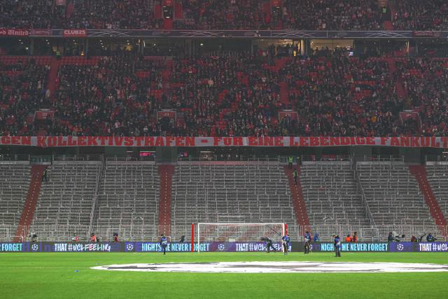 A banner reads "Against collective punishment - for a vibrant fan culture", as empty stands (Bottom) are seen before the start of the UEFA Champions League match between FC Bayern Munich (GER) and Union Saint Gilloise (BEL) in Munich, southern Germany, on January 21, 2026, after UEFA ordered the closure of the Suedkurve as a collective punishment following pyrotechnic incidents involving Bayern ultras. (Photo by Karl-Josef HILDENBRAND / AFP)
