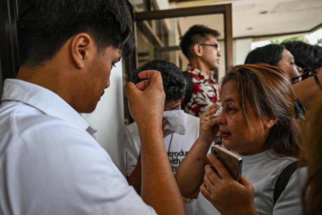 Lala Cumpio (R), mother of the detained Filipino journalist Frenchie Mae Cumpio, cries outside the Tacloban Regional Trial Court in Leyte island on January 22, 2026, after the promulgation of her daughter's court case. Cumpio, who spent nearly six years in a crowded provincial prison, was found guilty of terror financing in a case rights groups and a UN rapporteur had labelled a "travesty of justice". (Photo by Jam STA ROSA / AFP)