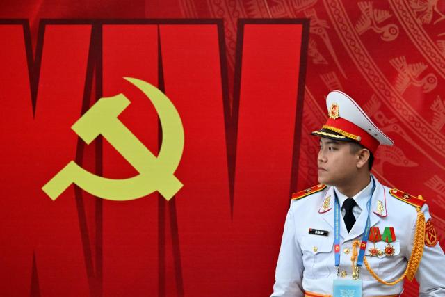 A soldier stands next to the logo of the Communist Party of Vietnam at the National Convention Center in Hanoi on January 22, 2026. (Photo by Nhac NGUYEN / AFP)