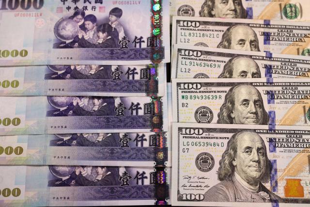 This photo illustration taken in Taipei on January 22, 2026 shows US 100 dollar and Taiwan 1000 dollar banknotes. (Photo by I-Hwa Cheng / AFP)