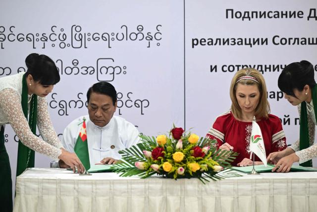 The Union Solidarity and Development Party (USDP) chairman U Khin Yi (2nd L) signs a cooperation agreement with Olga Chemodanova (2nd R), newly elected chairperson of Belarusian political party Belaya Rus, during a ceremony at the Sky Star Hotel in Yangon on January 22, 2026. (Photo by AFP)