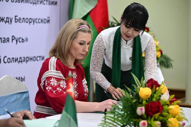 Olga Chemodanova (L), newly elected chairperson of Belarusian political party Belaya Rus, signs a cooperation agreement with Union Solidarity and Development Party (USDP) chairman U Khin Yi, during a ceremony at the Sky Star Hotel in Yangon on January 22, 2026. (Photo by AFP)