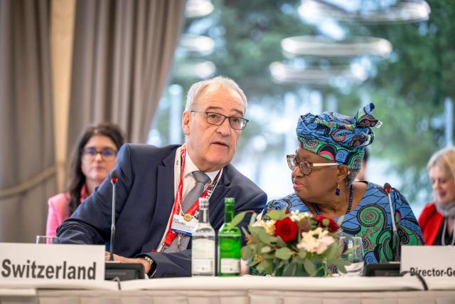 Switzerland's President Guy Parmelin (L) speaks with World Trade Organization’s Director-General Ngozi Okonjo-Iweala during a World Trade Organization (WTO) Informal ministerial gathering on the sidelines of the World Economic Forum (WEF) annual meeting in Davos on January 22, 2026. The World Economic Forum takes place in Davos from January 19 to January 23, 2026. (Photo by LAURENT GILLIERON / POOL / AFP)