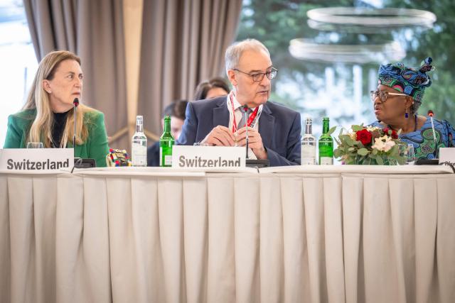 Switzerland's President Guy Parmelin (C) speaks with World Trade Organizations Director-General Ngozi Okonjo-Iweala (R) next to Switzerland's director of the State Secretariat for Economic Affairs (SECO) Helene Budliger Artieda during a World Trade Organization (WTO) Informal ministerial gathering on the sidelines of the World Economic Forum (WEF) annual meeting in Davos on January 22, 2026. The World Economic Forum takes place in Davos from January 19 to January 23, 2026. (Photo by LAURENT GILLIERON / POOL / AFP)