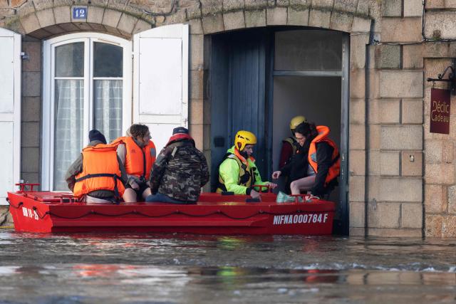 People are evacuated from their home during flooding caused by the overflowing of the Laita River in Quimperle, western France, on January 22, 2026. (Photo by Fred TANNEAU / AFP)