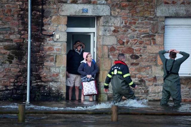 People are evacuated from their home during flooding caused by the overflowing of the Laita River in Quimperle, western France, on January 22, 2026. (Photo by Fred TANNEAU / AFP)