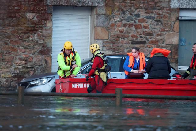 People are evacuated from their home during flooding caused by the overflowing of the Laita River in Quimperle, western France, on January 22, 2026. (Photo by Fred TANNEAU / AFP)