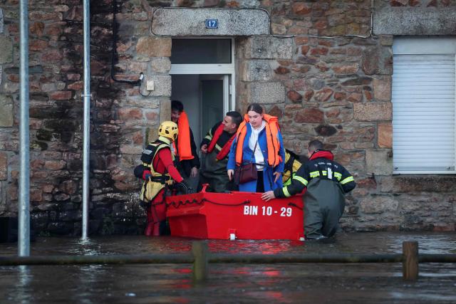 People are evacuated from their home during flooding caused by the overflowing of the Laita River in Quimperle, western France, on January 22, 2026. (Photo by Fred TANNEAU / AFP)