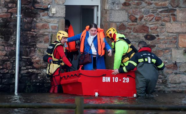 People are evacuated from their home during flooding caused by the overflowing of the Laita River in Quimperle, western France, on January 22, 2026. (Photo by Fred TANNEAU / AFP)