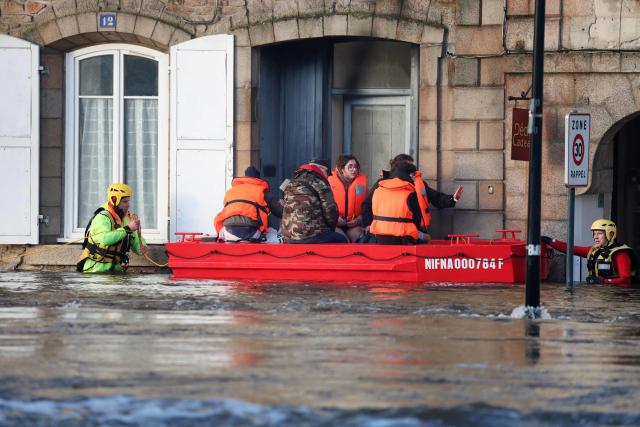 People are evacuated from their home during flooding caused by the overflowing of the Laita River in Quimperle, western France, on January 22, 2026. (Photo by Fred TANNEAU / AFP)