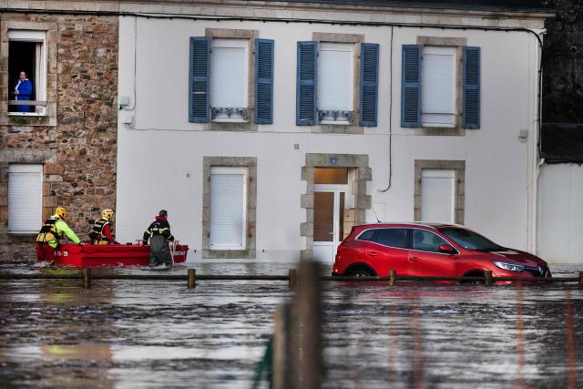 People are evacuated from their home during flooding caused by the overflowing of the Laita River in Quimperle, western France, on January 22, 2026. (Photo by Fred TANNEAU / AFP)