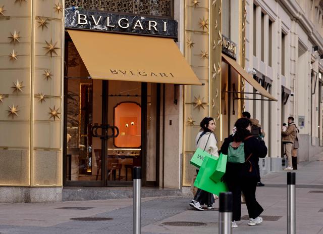 Pedestrians walk past luxury shops in the Ortega y Gasset street in Madrid on January 20, 2026. Madrid has emerged as a coveted global luxury housing destination as Latin American and US investors fuel a real estate boom, seduced by competitive prices and high living standards. (Photo by OSCAR DEL POZO / AFP)