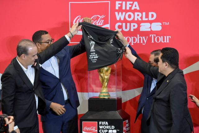 (L-R) President of The Coca-Cola Company for ASEAN and South Pacific Selman Careaga, former Brazil player Gilberto Silva, Governor of Jakarta Pramono Anung, and Minister of Youth and Sports Erick Thohir unveil the trophy during the original FIFA World Cup 2026 Trophy Tour in Jakarta on January 22, 2026. (Photo by BAY ISMOYO / AFP)