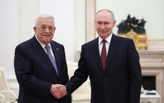 Russian President Vladimir Putin shakes hands with Palestinian President Mahmoud Abbas during a meeting at the Kremlin in Moscow on January 22, 2026. (Photo by Ramil Sitdikov / POOL / AFP)