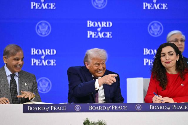 Pakistan's Prime Minister Shehbaz Sharif (L) and Kosovo's President Vjosa Osmani speak with US President Donald Trump at the "Board of Peace" meeting during the World Economic Forum (WEF) annual meeting in Davos on January 22, 2026. US President Donald Trump will show off his new "Board of Peace" at Davos on January 22, 2026 burnishing his claim to be a peacemaker a day after backing off his own threats against Greenland. Originally meant to oversee the rebuilding of Gaza after the war between Hamas and Israel, the board's charter does not limit its role to the Strip, and has sparked concerns that Trump wants it to rival the United Nations. (Photo by Fabrice COFFRINI / AFP)