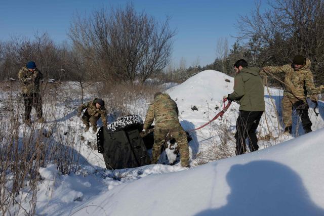 A Ukrainian servicemen from the 5th Separate Assault brigade pull out of the pit an unmanned ground vehicle during a training at an undisclosed location in Dnipropetrovsk region on January 21, 2026, amid the Russian invasion of Ukraine. (Photo by Tetiana DZHAFAROVA / AFP)