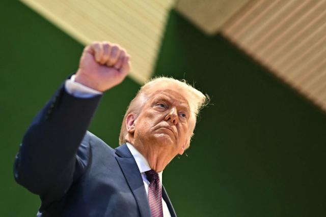 US President Donald Trump rises his fist after the "Board of Peace" meeting during the World Economic Forum (WEF) annual meeting in Davos on January 22, 2026. US President Donald Trump will show off his new "Board of Peace" at Davos on January 22, 2026 burnishing his claim to be a peacemaker a day after backing off his own threats against Greenland. Originally meant to oversee the rebuilding of Gaza after the war between Hamas and Israel, the board's charter does not limit its role to the Strip, and has sparked concerns that Trump wants it to rival the United Nations. (Photo by Fabrice COFFRINI / AFP)