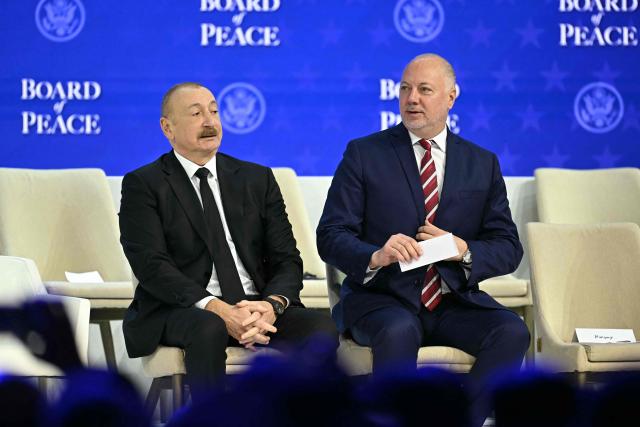 Azerbaijan's President Ilham Aliyev and Bulgaria's former Prime Minister Rosen Zhelyazkov attend the "Board of Peace" meeting during the World Economic Forum (WEF) annual meeting in Davos on January 22, 2026. US President Donald Trump will show off his new "Board of Peace" at Davos on January 22, 2026 burnishing his claim to be a peacemaker a day after backing off his own threats against Greenland. Originally meant to oversee the rebuilding of Gaza after the war between Hamas and Israel, the board's charter does not limit its role to the Strip, and has sparked concerns that Trump wants it to rival the United Nations. (Photo by Fabrice COFFRINI / AFP)