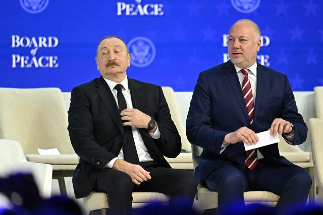 Azerbaijan's President Ilham Aliyev and Bulgaria's former Prime Minister Rosen Zhelyazkov attend the "Board of Peace" meeting during the World Economic Forum (WEF) annual meeting in Davos on January 22, 2026. US President Donald Trump will show off his new "Board of Peace" at Davos on January 22, 2026 burnishing his claim to be a peacemaker a day after backing off his own threats against Greenland. Originally meant to oversee the rebuilding of Gaza after the war between Hamas and Israel, the board's charter does not limit its role to the Strip, and has sparked concerns that Trump wants it to rival the United Nations. (Photo by Fabrice COFFRINI / AFP)