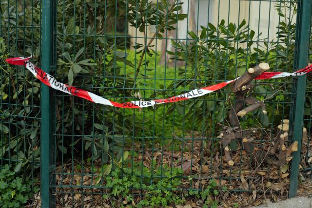This photograph shows a French Police tape set by a traffic lampost bent by the car of a woman murdered while driving with her baby in Nice, southeastern France, on January 22, 2026. The tragedy took place on January 21, 226 shortly after 6 pm at an intersection near a high school in the west of the city. A man on a scooter pulled up alongside the driver and fired about ten shots at point-blank range through the vehicle's window, Nice prosecutor said in a statement. (Photo by Valery HACHE / AFP)