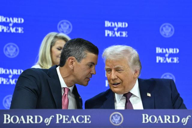Paraguay's President Santiago Pena (L) speaks with US President Donald Trump at the "Board of Peace" meeting during the World Economic Forum (WEF) annual meeting in Davos on January 22, 2026. US President Donald Trump will show off his new "Board of Peace" at Davos on January 22, 2026 burnishing his claim to be a peacemaker a day after backing off his own threats against Greenland. Originally meant to oversee the rebuilding of Gaza after the war between Hamas and Israel, the board's charter does not limit its role to the Strip, and has sparked concerns that Trump wants it to rival the United Nations. (Photo by Mandel NGAN / AFP)