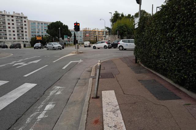 This photograph shows a traffic lampost bent by the car of a woman murdered while driving with her baby in Nice, southeastern France, on January 22, 2026. The tragedy took place on January 21, 226 shortly after 6 pm at an intersection near a high school in the west of the city. A man on a scooter pulled up alongside the driver and fired about ten shots at point-blank range through the vehicle's window, Nice prosecutor said in a statement. (Photo by Valery HACHE / AFP)