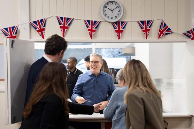 Britain's Prime Minister Keir Starmer (C) meets with local residents to discuss the government's Warm Homes Plan, during a visit to a community group at the Flaunden Village Hall near Hemel Hempstead, Hertfordshire, north of London on January 22, 2026. (Photo by Stefan Rousseau / POOL / AFP)