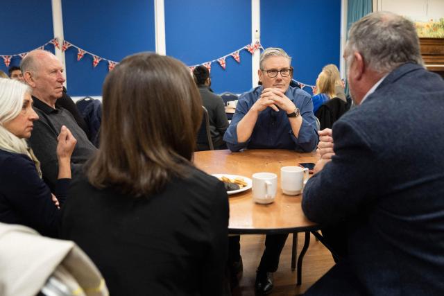 Britain's Prime Minister Keir Starmer (R-facing) meets with local residents to discuss the government's Warm Homes Plan, during a visit to a community group at the Flaunden Village Hall near Hemel Hempstead, Hertfordshire, north of London on January 22, 2026. (Photo by Stefan Rousseau / POOL / AFP)
