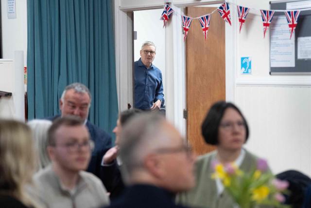 Britain's Prime Minister Keir Starmer (behind) prepares to meet with local residents to discuss the government's Warm Homes Plan, during a visit to a community group at the Flaunden Village Hall near Hemel Hempstead, Hertfordshire, north of London on January 22, 2026. (Photo by Stefan Rousseau / POOL / AFP)