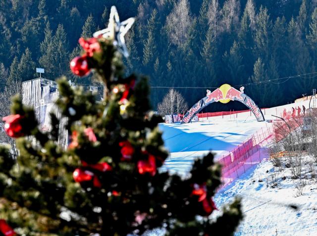 The ski slope with the "Red Bull jump" at the famous "Streif" (Hahnenkamm downhill course) is seen behind a Christmas tree at the ski resort of Kitzbuehel, Austria on a free day of the Men's FIS Alpine Skiing World Cup Austria on January 22, 2026. (Photo by Joe Klamar / AFP)