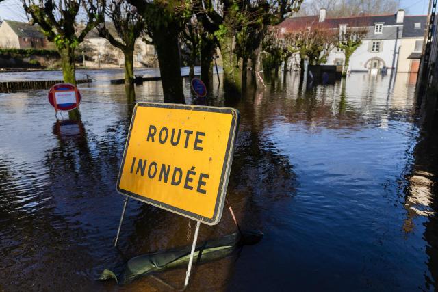This photograph shows a road sign which reads as "Flooded Street" displayed in Quimperle, western France on January 22, 2026. Finistиre and Morbihan departments of western France are on orange alert on January 21, 2026, for “rain and flooding”. (Photo by Fred TANNEAU / AFP)