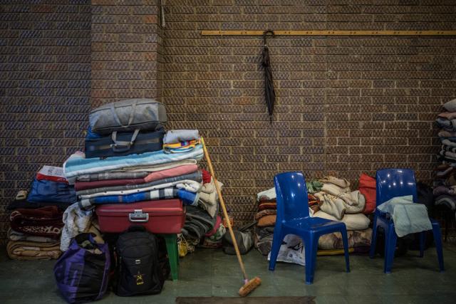 Personal belongings of residents displaced from the informal settlement of Sporong by the ongoing unrest between the community and  a group of artisanal miners commonly referred to as "zama zamas", are neatly kept at the Randgate Community Hall in Randfontein, on January 22, 2026 where the displaced took refuge. Residents and local officials blame artisanal miners, long associated with sudden eruptions of violence, running gun battles and the shadowy networks that sustain South Africa's illicit gold trade. 
Known locally as "zama zamas" -- "those who try" in the Zulu language -- they have become an entrenched presence in the shantytowns that ring Johannesburg and its satellite settlements along the gold reef. (Photo by MARCO LONGARI / AFP)