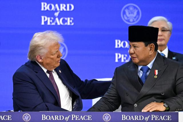 US President Donald Trump (L) shakes hands with Indonesia's President Prabowo Subianto at the "Board of Peace" meeting during the World Economic Forum (WEF) annual meeting in Davos on January 22, 2026. US President Donald Trump will show off his new "Board of Peace" at Davos on January 22, 2026 burnishing his claim to be a peacemaker a day after backing off his own threats against Greenland. Originally meant to oversee the rebuilding of Gaza after the war between Hamas and Israel, the board's charter does not limit its role to the Strip, and has sparked concerns that Trump wants it to rival the United Nations. (Photo by Fabrice COFFRINI / AFP)