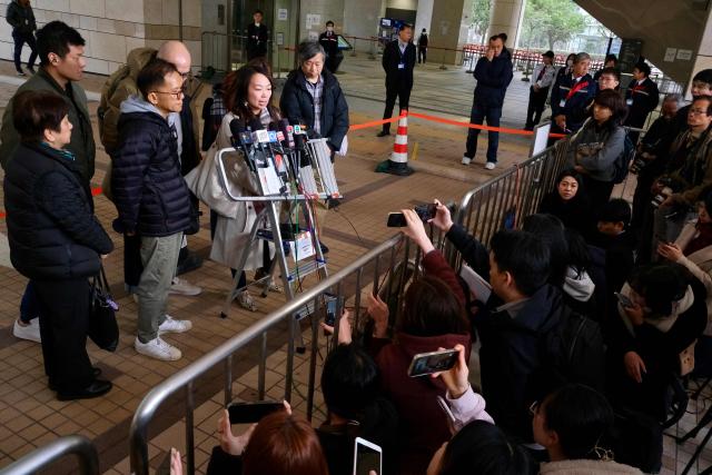 Relatives of Lamma IV ferry disaster victims speak to reporters at Hong Kong's West Kowloon Law Courts Building after the city's coroner delivered the verdict on the accident, which killed 39 in total in 2012, on January 22, 2026. Family members of those killed in a Hong Kong ferry collision were "outraged" by a long-awaited coroner's verdict, saying on January 22, it offered little by way of accountability or closure. (Photo by Tommy WANG / AFP)
