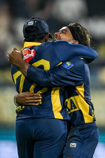 Sri Lanka's Dunith Wellalage (R) celebrates with captain Charith Asalanka after taking a catch to dismiss England's Jamie Overton during the first one-day international (ODI) cricket match between Sri Lanka and England at the R. Premadasa International Cricket Stadium in Colombo on January 22, 2026. (Photo by Ishara S. KODIKARA / AFP)