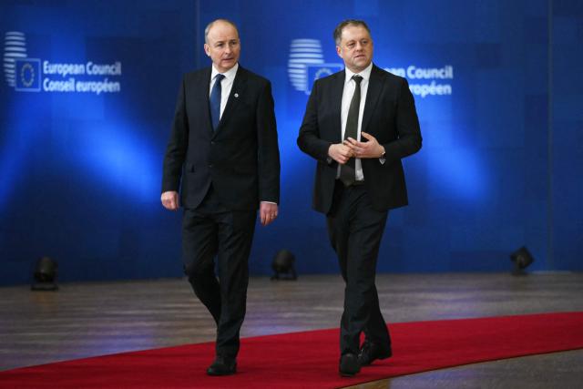 Ireland's Taoiseach Micheál Martin (L) arrives for a European Council meeting to discuss recent developments in transatlantic relations, in Brussels, on January 22, 2026. EU leaders meet on January 22, 2026, for an emergency summit on threats by US President to impose tariffs on countries opposed to his push to take Greenland, with crisis talks in Brussels coming to weigh potential countermeasures against the United States. (Photo by NICOLAS TUCAT / AFP)