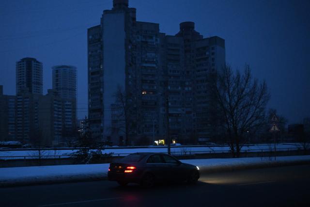 A car drives in a residential area of Kyiv that has been left without electricity and water due to recent Russian strikes battering the energy sector, on January 22, 2026, amid the Russian invasion of Ukraine. (Photo by Sergei GAPON / AFP)