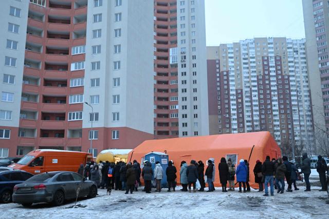 Local residents queue to receive hot meal distributed by volunteers of the US-based food charity World Central Kitchen in a residential area of Kyiv that has been left without electricity and water due to recent Russian strikes battering the energy sector on January 22, 2026, amid the Russian invasion of Ukraine.  (Photo by Sergei GAPON / AFP)