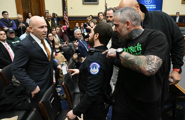 Far-right political operative Ivan Raiklin (L) confronts former Metropolitan Police Department officer Michael Fanone during a break in testimony by former US special counsel Jack Smith before the House Judiciary Committee on Capitol Hill in Washington, DC, on January 22, 2026. (Photo by SAUL LOEB / AFP)