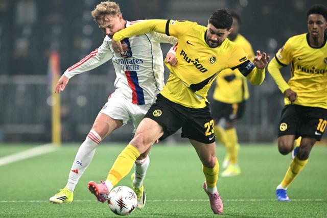 Lyon's Czech forward #07 Adam Karabec (L) and Young Boys' Swiss defender #23 Loris Benito (C) fight for the ball during the UEFA Europa League, league phase, football match between Young Boys and Olympique Lyonnais (OL) at the Wankdorf stadium in Bern on January 22, 2026. (Photo by Sébastien BOZON / AFP)