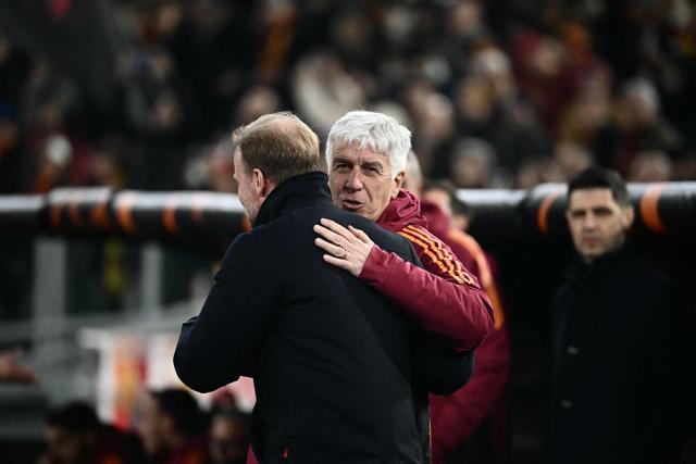 Roma's Italian coach Gian Pieo Gasperini (L) and Stuttgart's German head coach Sebastian Hoenes hug at the start of the Europa League 1st round day 7 football match between AS Roma and VfB Stuttgart at Stadio Olimpico in Rome on January 22, 2026. (Photo by Filippo MONTEFORTE / AFP)