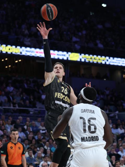 AS Monaco's Serbian guard #26 Nemanja Nedovic attempts a shot in spite of Real Madrid's Spanish forward #16 Usman Garuba during the Euroleague basketball match between Real Madrid Baloncesto and Monaco at Movistar Arena in Madrid on January 22, 2026. (Photo by Thomas COEX / AFP)