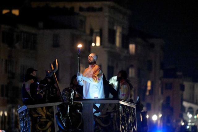 Torchbearer Amedeo Tessitori, basketball player, carries the Olympic flame in Venice during the Torch Relay to Milano Cortina 2026 Olympic Games, on January 22, 2026. (Photo by ANDREA PATTARO / AFP)
