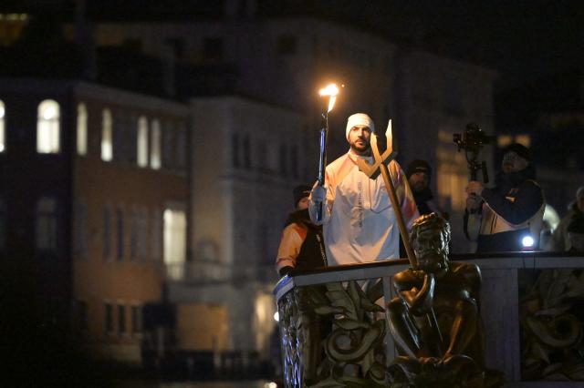 Torchbearer Amedeo Tessitori, basketball player, carries the Olympic flame in Venice during the Torch Relay to Milano Cortina 2026 Olympic Games, on January 22, 2026. (Photo by ANDREA PATTARO / AFP)