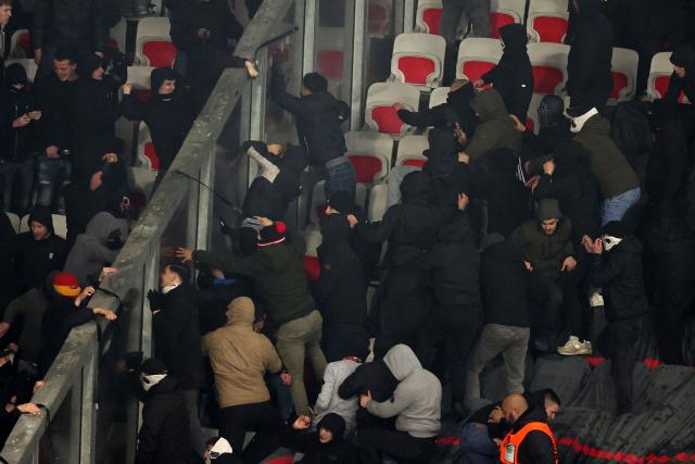 Go Ahead Eagles' supporters (L) and Nice's supporters (R) scuffle during the Europa League football match between OGC Nice and Go Ahead Eagles at Allianz Riviera stadium in Nice on January 22, 2026. (Photo by Valery HACHE / AFP)