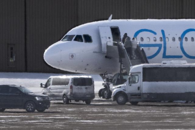 Shackled deportees board a GlobalX plane at the Minneapolis-Saint Paul International Airport in Minneapolis, Minnesota on January 22, 2026. According to the US Department of Homeland Security, more than 675,000 deportations were conducted in 2025. (Photo by ROBERTO SCHMIDT / AFP)