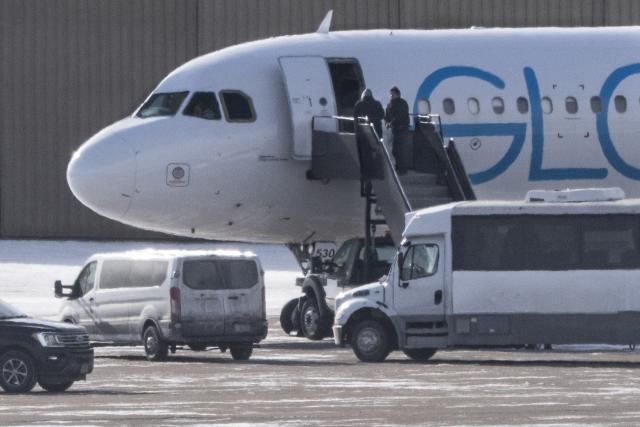Shackled deportees board a GlobalX plane at the Minneapolis-Saint Paul International Airport in Minneapolis, Minnesota on January 22, 2026. According to the US Department of Homeland Security, more than 675,000 deportations were conducted in 2025. (Photo by ROBERTO SCHMIDT / AFP)