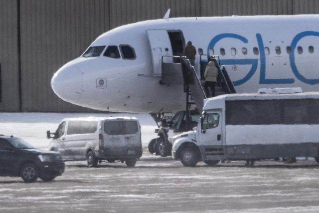 Shackled deportees board a GlobalX plane at the Minneapolis-Saint Paul International Airport in Minneapolis, Minnesota on January 22, 2026. According to the US Department of Homeland Security, more than 675,000 deportations were conducted in 2025. (Photo by ROBERTO SCHMIDT / AFP)