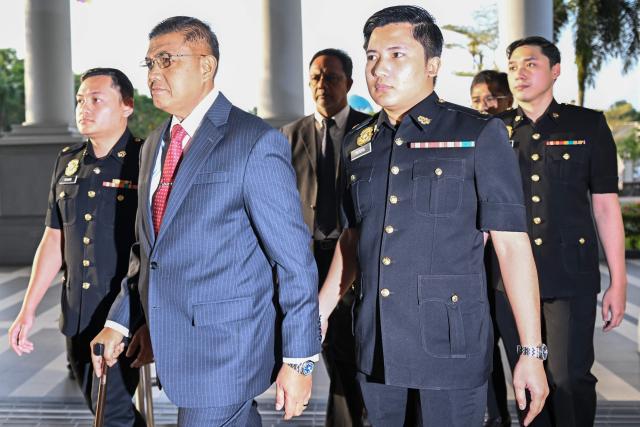 Former Malaysia's armed forces chief Nizam Jaffar (2nd-L) is escorted by Malaysian Anti-Corruption Commission (MACC) officers to a special court in Kuala Lumpur on January 23, 2026. (Photo by Mohd RASFAN / AFP)